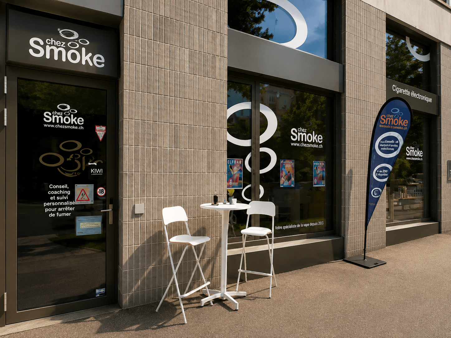 Entrée de la boutique de cigarettes électroniques chez Smoke à Delémont avec son espace test e-liquide en terrasse.